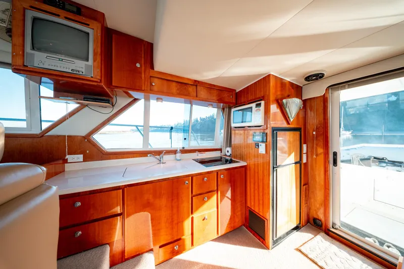  Yacht Photos Pics Luxurious 2003 Navigator 3900 yacht interior with kitchen, TV, and scenic window views.