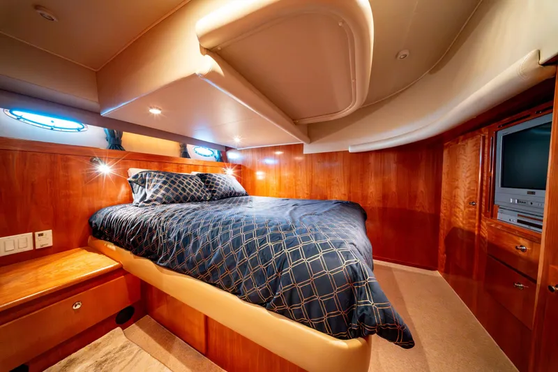 Yacht Photos Pics Luxurious bedroom interior of 2003 Navigator 3900 yacht with wood paneling and cozy bedding.