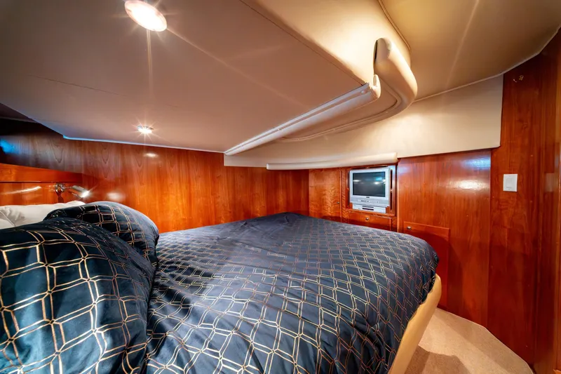  Yacht Photos Pics Luxurious cabin interior of 2003 Navigator 3900 yacht with wood paneling and cozy bedding.