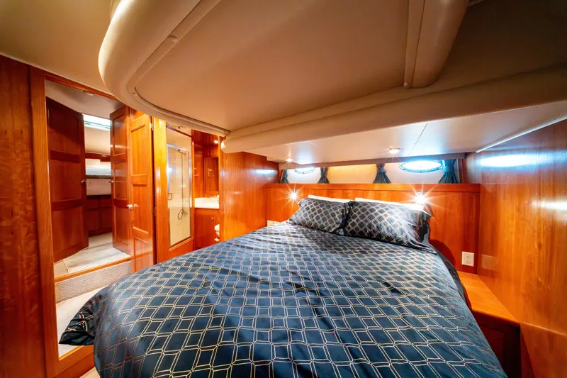  Yacht Photos Pics Luxurious bedroom interior of 2003 Navigator 3900 yacht with wood paneling and cozy bedding.
