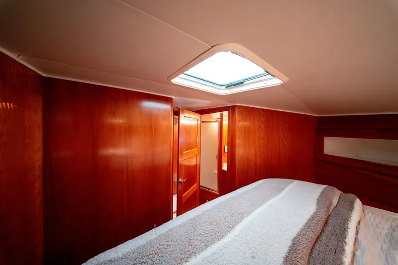  Yacht Photos Pics Cozy bedroom interior of 2003 Navigator 3900 yacht with wooden paneling and skylight.