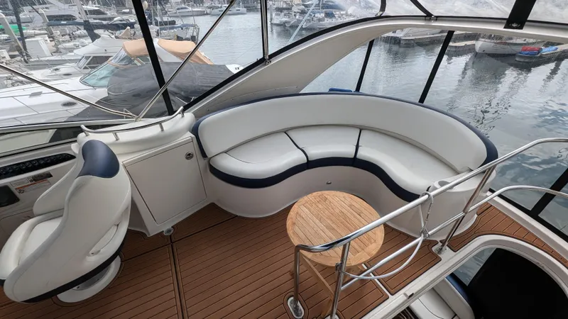 Yacht Photos Pics 2008 Meridian 341 Sedan yacht interior with curved seating and wooden deck, overlooking marina.