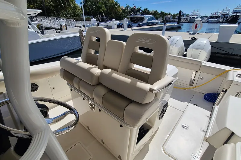 Timber Yacht Photos Pics 2023 Boston Whaler 330 Outrage boat interior with dual helm seats at marina.