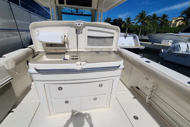 Timber Yacht Photos Pics 2023 Boston Whaler 330 Outrage boat interior with storage and sink, docked under clear blue sky.