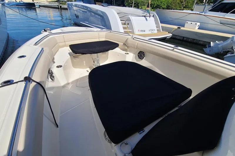 Timber Yacht Photos Pics 2023 Boston Whaler 330 Outrage boat interior with black seating, docked at marina.