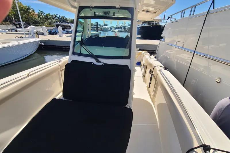 Timber Yacht Photos Pics 2023 Boston Whaler 330 Outrage boat interior at marina, showcasing seating and helm area.