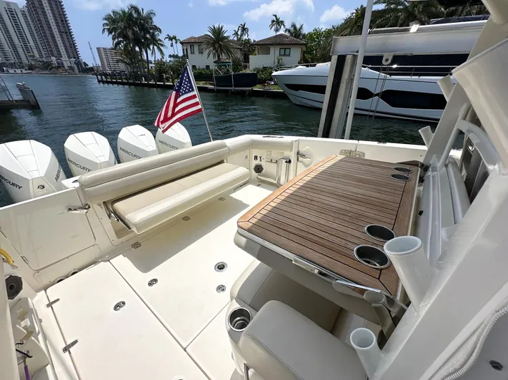  Yacht Photos Pics 2021 Boston Whaler 380 Outrage boat deck with seating, table, and American flag.