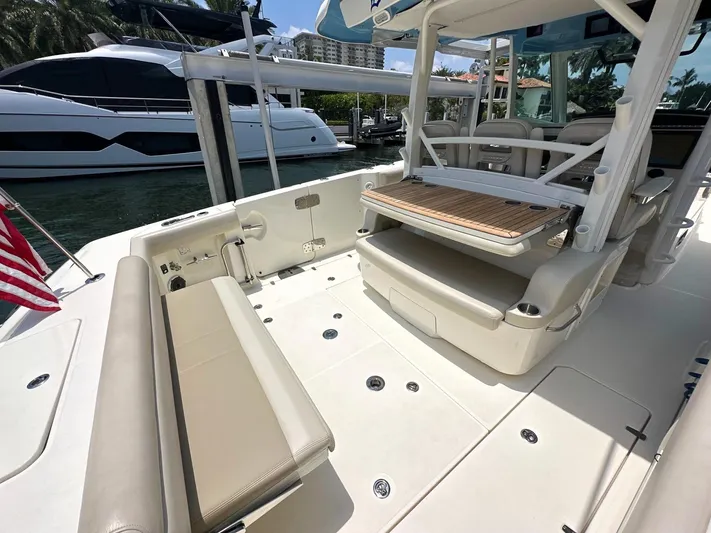  Yacht Photos Pics 2021 Boston Whaler 380 Outrage boat interior with seating and deck, docked near other yachts.