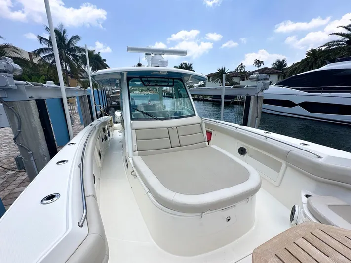  Yacht Photos Pics 2021 Boston Whaler 380 Outrage boat docked, featuring spacious seating and sleek design.