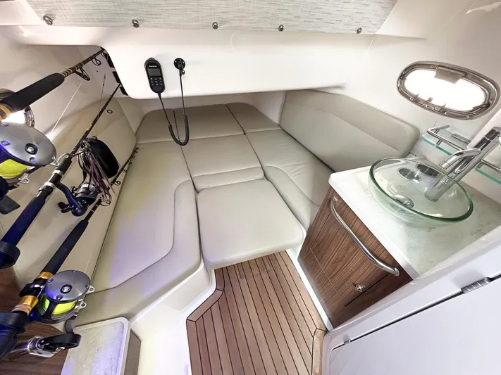 Yacht Photos Pics 2021 Boston Whaler 380 Outrage cabin interior with fishing rods and compact kitchenette.