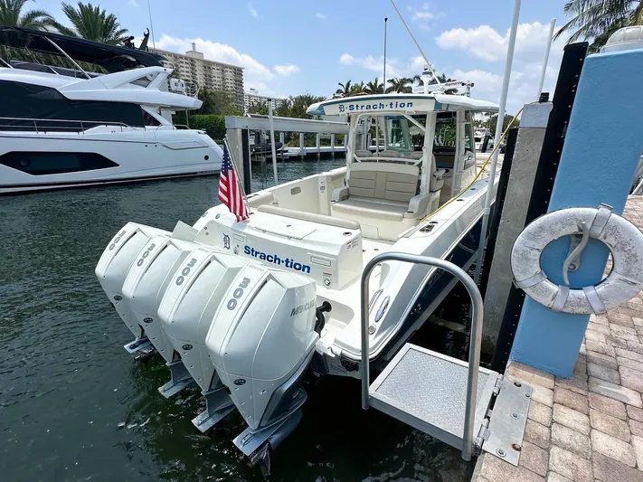  Yacht Photos Pics 2021 Boston Whaler 380 Outrage docked, featuring triple outboard engines and American flag.