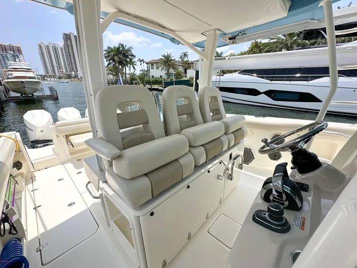  Yacht Photos Pics 2021 Boston Whaler 380 Outrage boat interior with helm and seating, docked near luxury yachts.