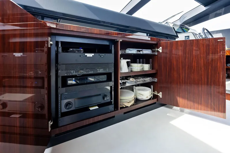 Our Trade Yacht Photos Pics Open cabinet with electronics and dishware on a 2021 Riva 88' FOLGORE yacht.