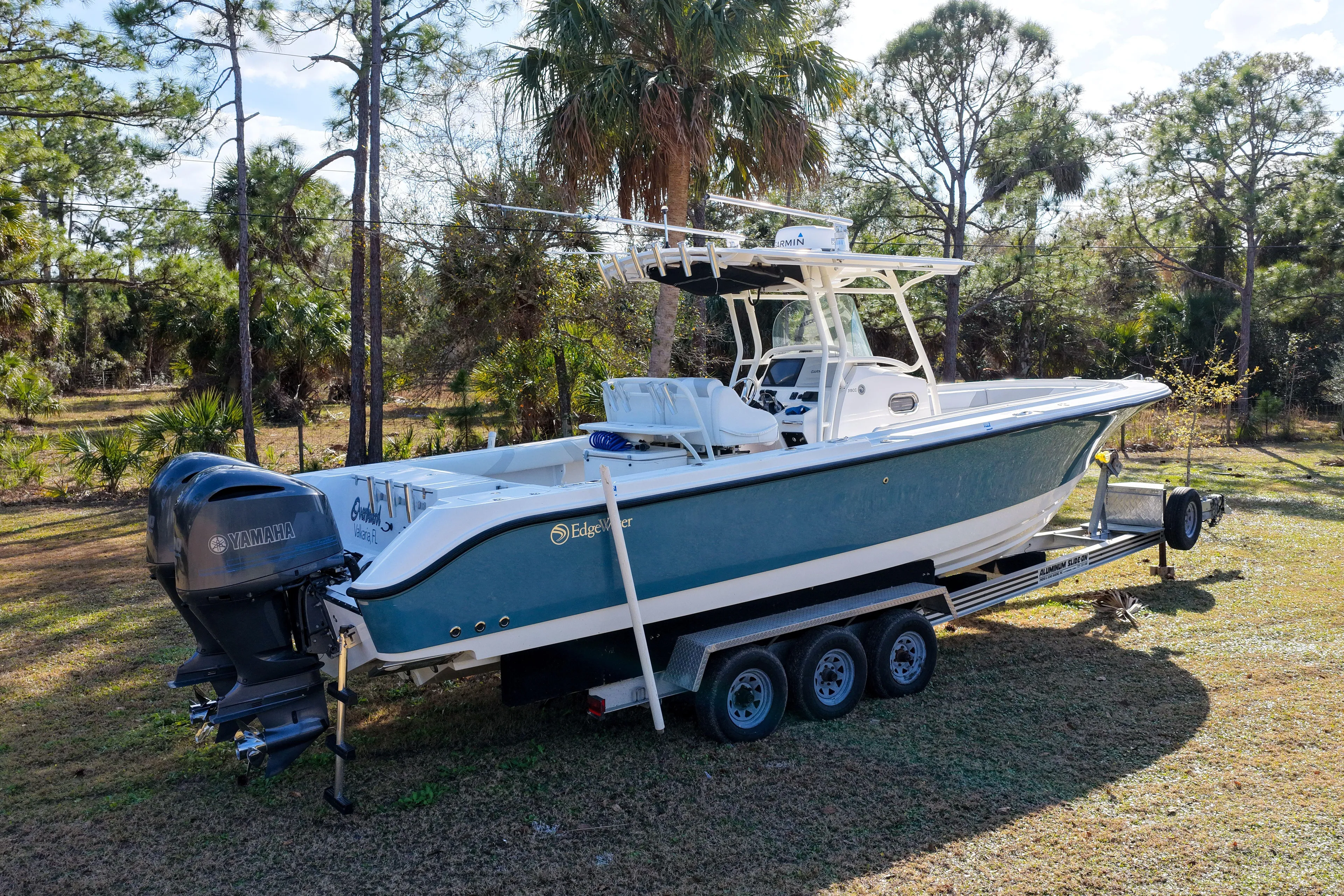  Yacht Photos Pics 2011 Edgewater 318CC boat on trailer, surrounded by trees and grass.