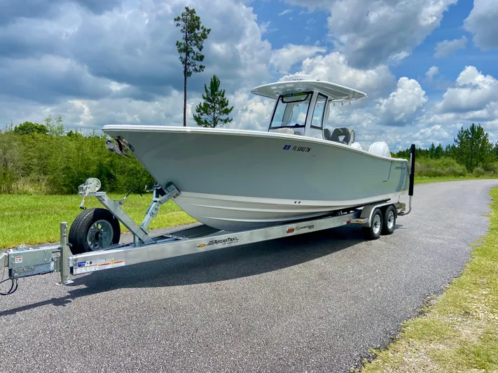 Yacht Photos Pics 2025 Sportsman Open 262 Center Console boat on trailer, parked on a rural road.