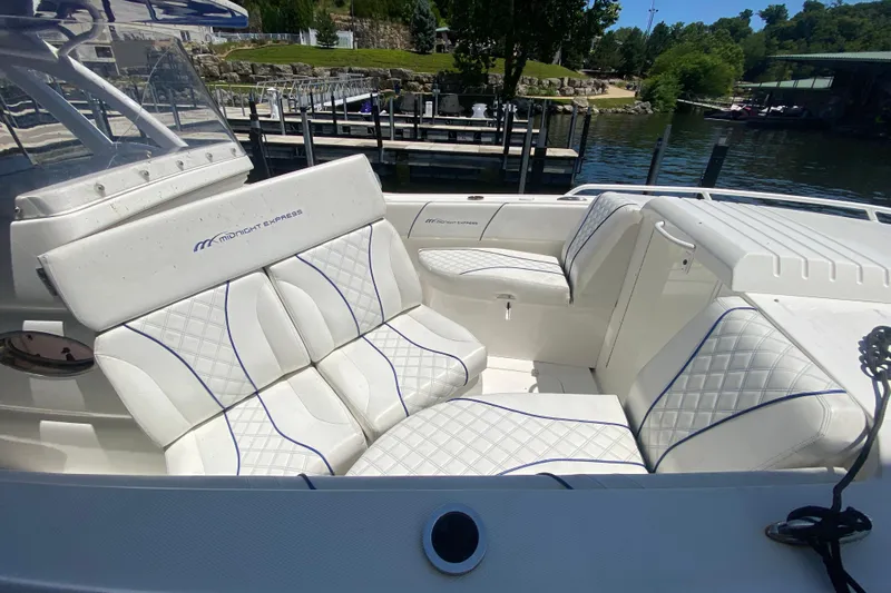  Yacht Photos Pics Luxurious seating on a 2017 Midnight Express 39S Cuddy boat, docked by a serene waterfront.