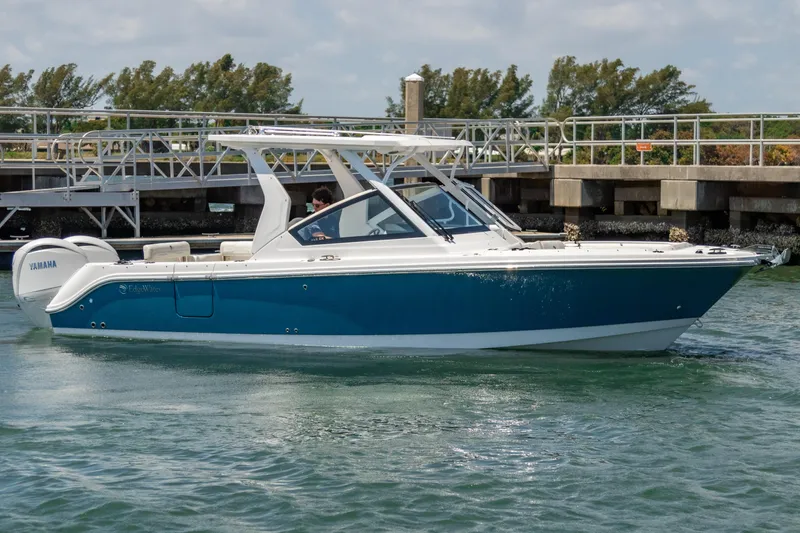  Yacht Photos Pics 2025 Edgewater 262 CX boat on water, blue and white design, dock in background.