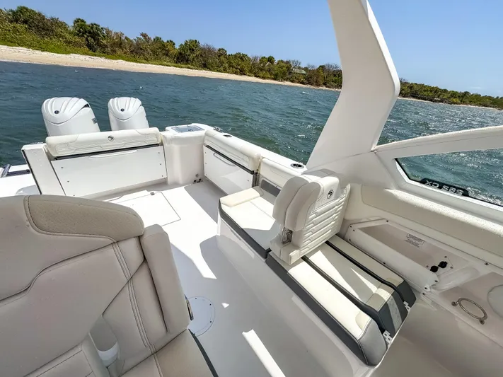  Yacht Photos Pics 2025 Edgewater 262 CX boat interior with seating, near shoreline, under clear blue sky.