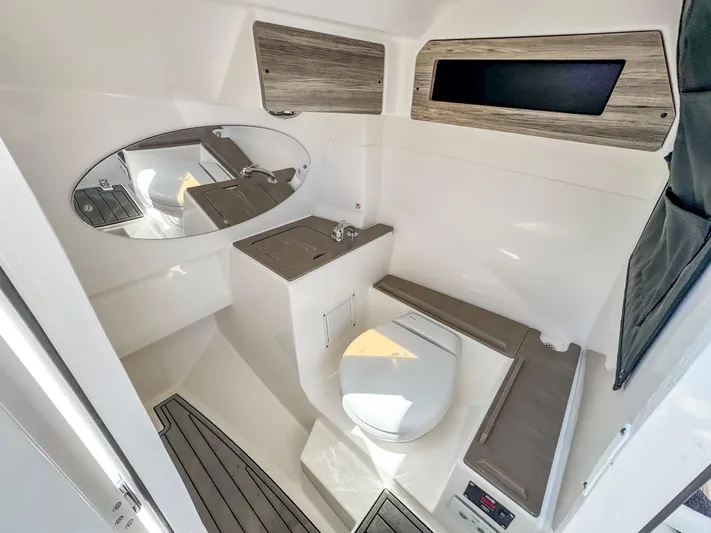  Yacht Photos Pics 2025 Edgewater 262 CX boat bathroom with modern fixtures and wood accents.