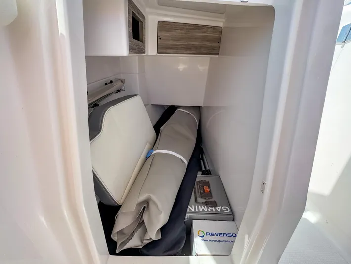  Yacht Photos Pics 2025 Edgewater 262 CX boat storage compartment with cushions and equipment.