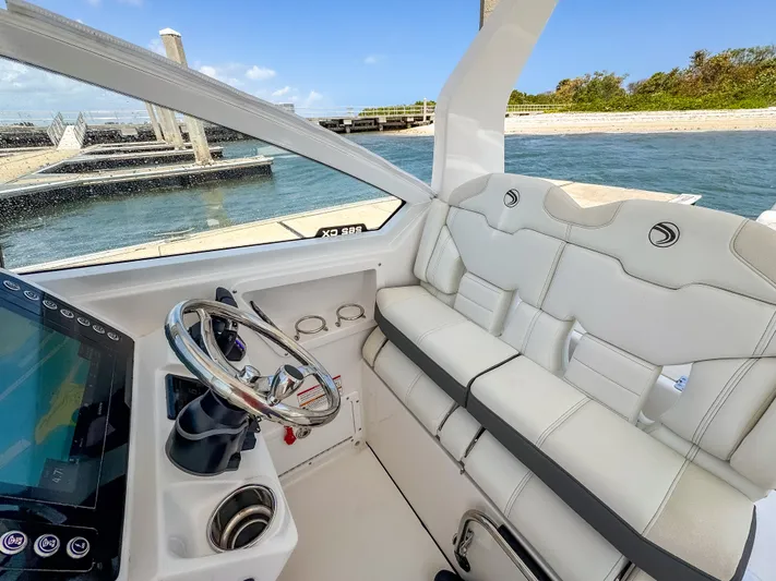  Yacht Photos Pics 2025 Edgewater 262 CX boat interior with white seating and steering wheel, dockside view.