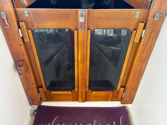 Andante Yacht Photos Pics Wooden cabin doors on a 1995 Island Packet 37 sailboat with a welcome mat.