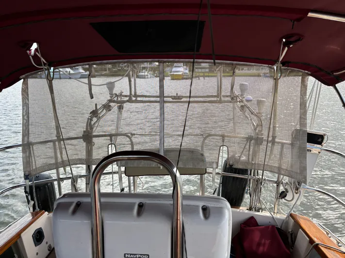 Andante Yacht Photos Pics 1995 Island Packet 37 sailboat cockpit with protective mesh and steering wheel.