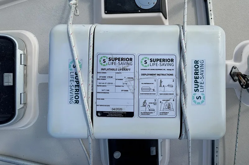 Andante Yacht Photos Pics Inflatable liferaft on 1995 Island Packet 37 sailboat, Superior Life-Saving brand, secured with ropes.