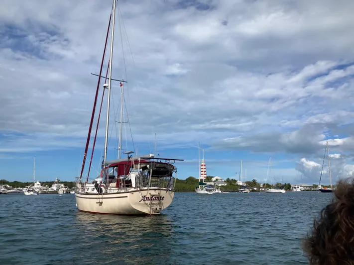 Andante Yacht Photos Pics Island Packet 37 sailboat from 1995 on calm waters, with a scenic coastal backdrop.
