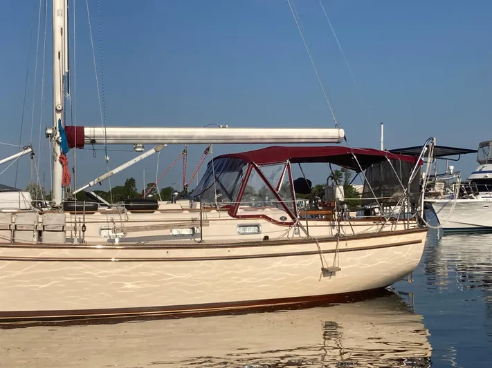 Andante Yacht Photos Pics 1995 Island Packet 37 sailboat docked on calm water under clear blue sky.