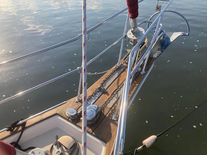 Andante Yacht Photos Pics Bow of 1995 Island Packet 37 sailboat with anchor and chain on calm water.