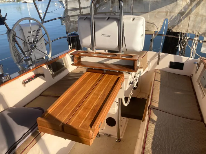 Andante Yacht Photos Pics 1995 Island Packet 37 sailboat cockpit with wooden table and cushioned seating.