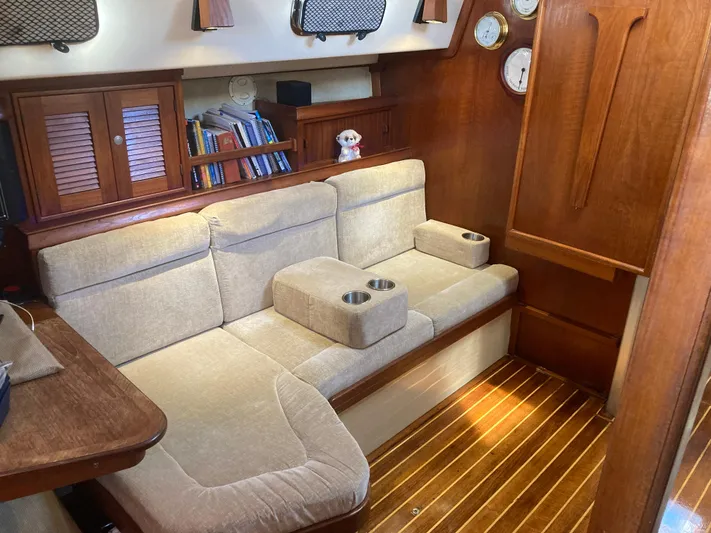 Andante Yacht Photos Pics Cozy interior of 1995 Island Packet 37 sailboat with beige seating and wooden accents.