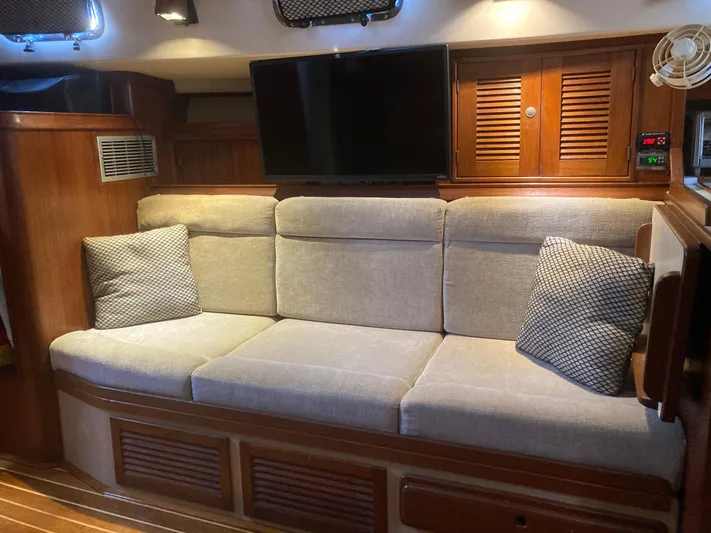 Andante Yacht Photos Pics Interior of 1995 Island Packet 37 yacht with cozy sofa and TV setup.