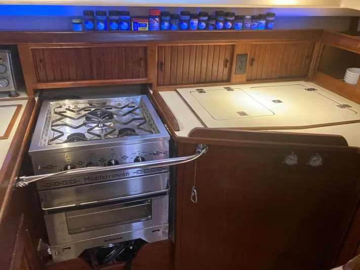 Andante Yacht Photos Pics Galley kitchen in 1995 Island Packet 37 sailboat with stove and spice rack.