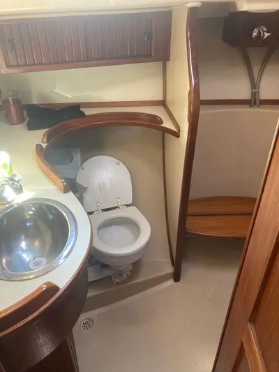 Andante Yacht Photos Pics 1995 Island Packet 37 yacht bathroom with sink, toilet, and wooden accents.