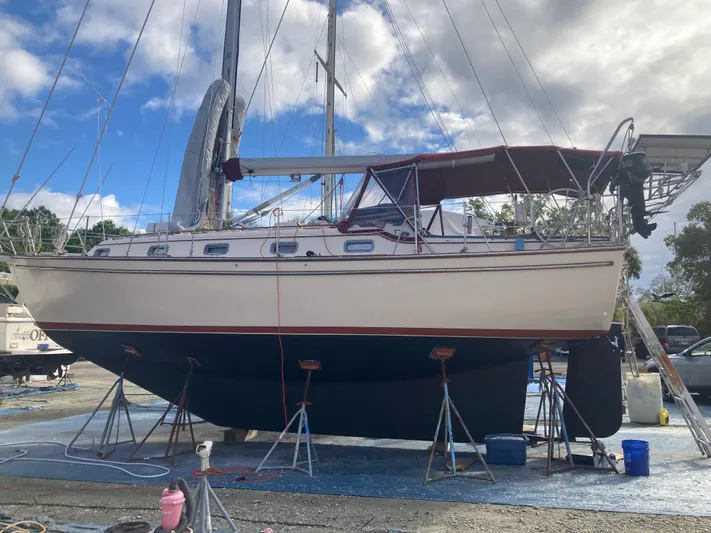 Andante Yacht Photos Pics 1995 Island Packet 37 sailboat on stands, under a cloudy sky.