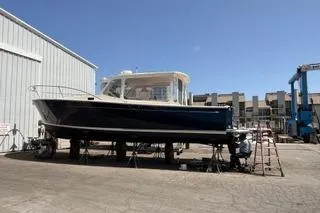Joy! Yacht Photos Pics 2005 MJM 34z Downeast boat on dry dock, sunny day, marina background.