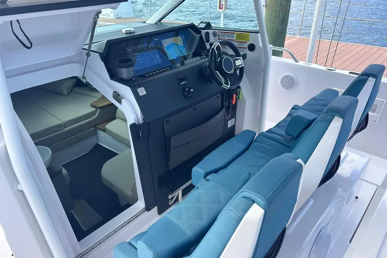  Yacht Photos Pics 2021 Axopar 37 Sun-Top cockpit with modern dashboard and blue seating.