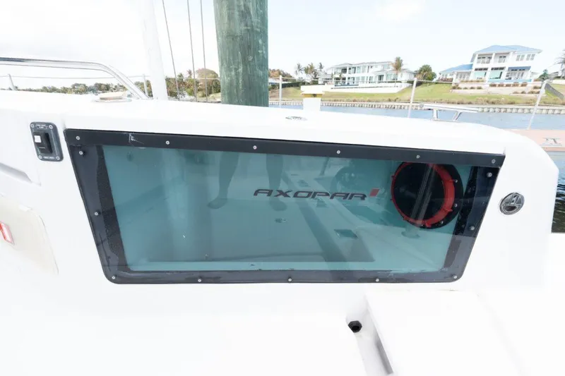  Yacht Photos Pics 2021 Axopar 37 Sun-Top boat window with logo, docked near waterfront homes.
