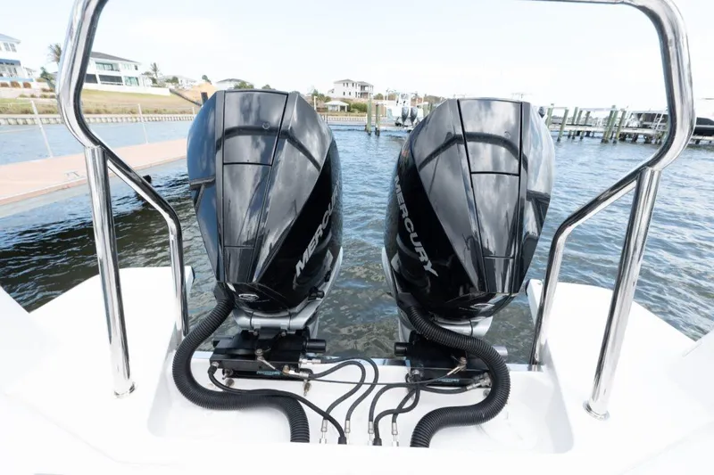  Yacht Photos Pics Twin Mercury outboard engines on a 2021 Axopar 37 Sun-Top boat, docked by the water.