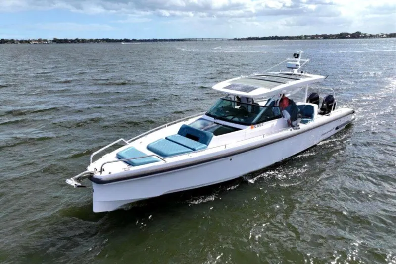  Yacht Photos Pics 2022 Axopar 37 Sun-Top boat cruising on open water under a cloudy sky.