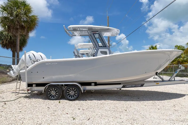  Yacht Photos Pics 2026 Sea Fox 268 Commander boat on trailer, parked outdoors under blue sky.