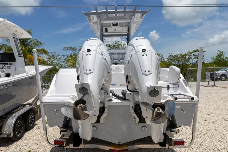  Yacht Photos Pics 2026 Sea Fox 268 Commander with dual outboard engines, parked on gravel lot.