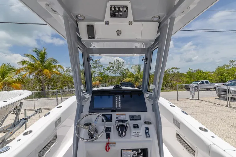  Yacht Photos Pics 2026 Sea Fox 268 Commander boat cockpit with steering wheel and control panel, parked outdoors.