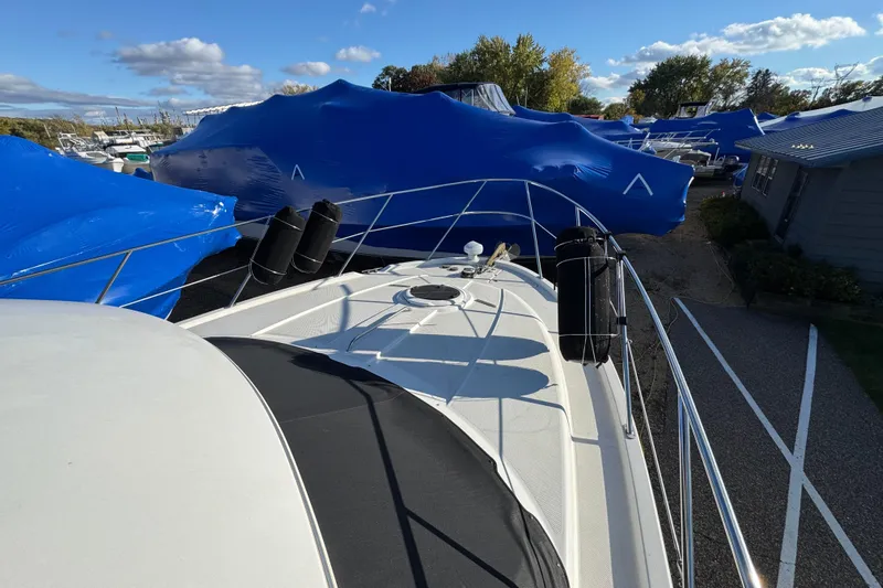 Comfort Zone Yacht Photos Pics 2005 Meridian 368 Motoryacht docked, surrounded by blue-covered boats under a clear sky.