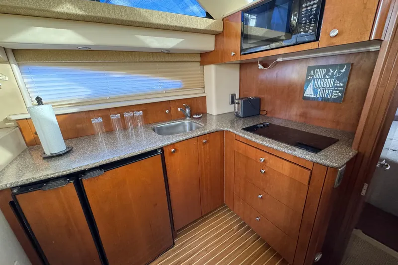 Comfort Zone Yacht Photos Pics 2005 Meridian 368 Motoryacht kitchen with wood cabinetry, countertop, sink, and appliances.