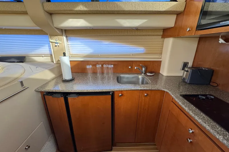 Comfort Zone Yacht Photos Pics 2005 Meridian 368 Motoryacht kitchen with wood cabinets, sink, and appliances.