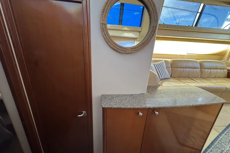 Comfort Zone Yacht Photos Pics 2005 Meridian 368 Motoryacht interior with wooden cabinetry, rope mirror, and leather seating.