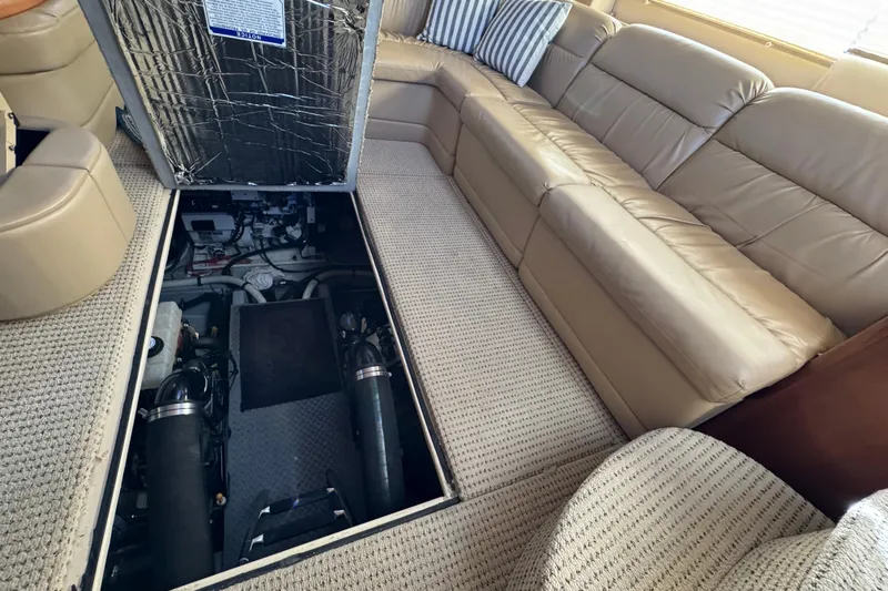 Comfort Zone Yacht Photos Pics 2005 Meridian 368 Motoryacht interior with open engine compartment, beige seating, and carpeted floor.
